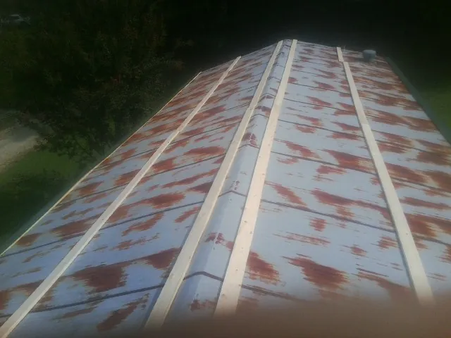 Rusted metal roof panels with new wood purlins before replacement — Storm Damage Roof Repair in James Creek by Roofing Brothers