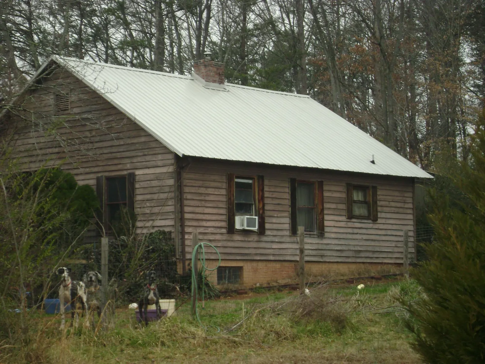 White metal roof on an old wood sided farmhouse, from a Metal Roof Installation job in James Creek